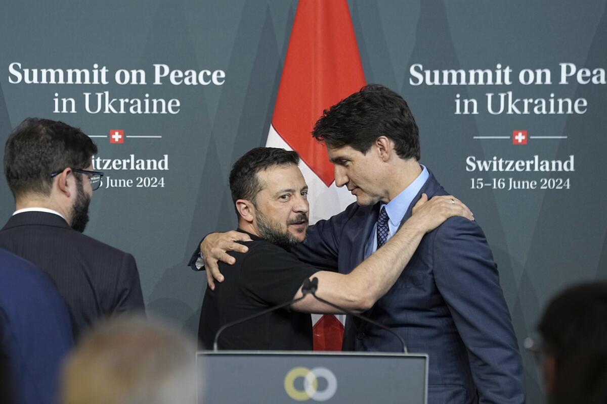 Ukraine's President Volodymyr Zelensky and Canada Prime Minister Justin Trudeau hug in Obbuergen, Switzerland.