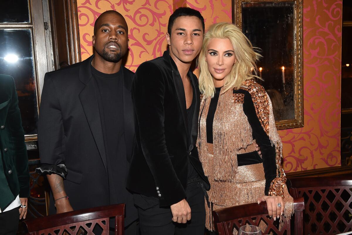 Kanye West, left, Balmain creative director Olivier Rousteing and the newly blond Kim Kardashian attend the Balmain after-show dinner on Thursday.