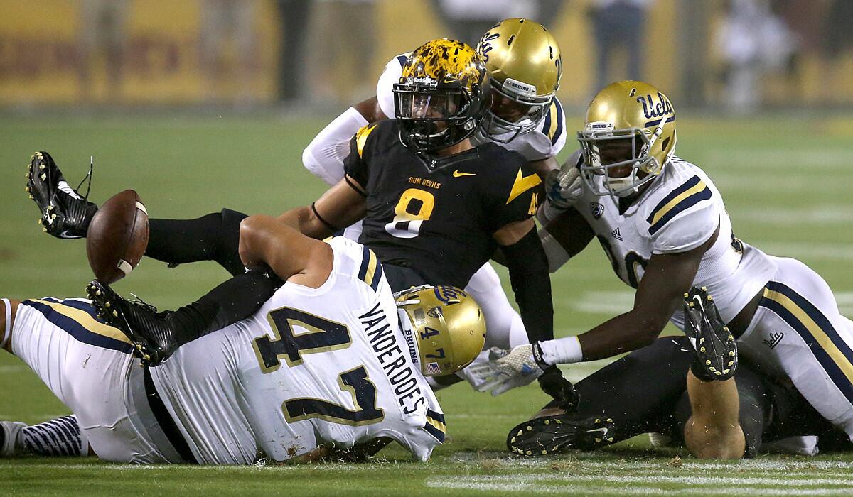 UCLA defensive tackle Eddie Vanderdoes (47) and teammates force Arizona State running back D.J. Foster to fumble during last week's game.