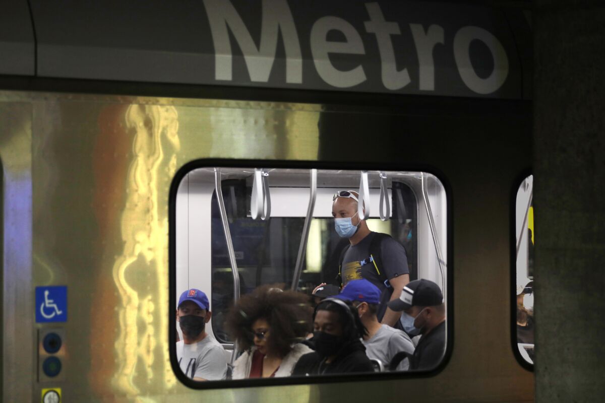 A view of Metro commuters through a train window.