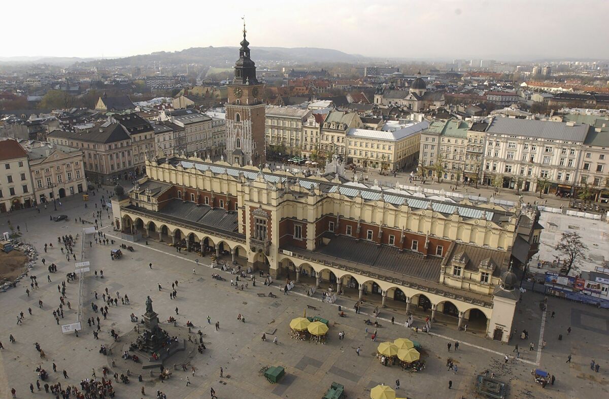 FILE - In this file photo taken on Nov. 3, 2004, A view of the Polish city of Krakow and its roofed cloth market, or Sukiennice, seen from the taller tower of St. Mary's Basilica. Every hour, a trumpeter plays the city's trademark bugle call from the tower's windows. Officials said Thursday, May 6, 2021, that the team of trumpeters, who are retired firefighters, was recently reinforced with two new players. (AP Photo/Czarek Sokolowski, file)