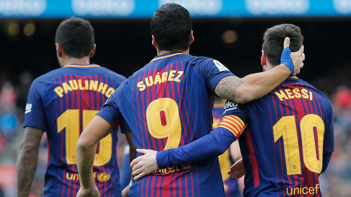 Barcelona's Luis Suarez celebrates a goal with teammate Lionel Messi during a match against RC Celta de Vigo on Dec. 2.