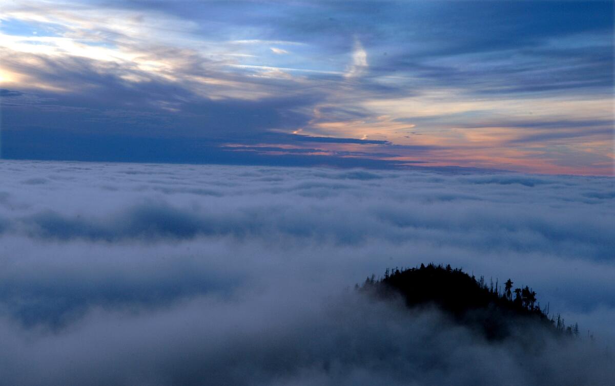 FILE - The sun sets over the Great Smoky Mountain National Park in this undated photo taken from the vantage point of Cliff Top near LeConte Lodge. Beginning March 2023, visitors to the national park will need to purchase a parking pass to use the facilities. (Joe Howell/Knoxville News Sentinel via AP, File)