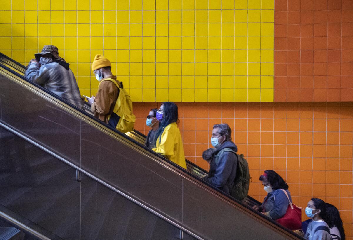 Metro commuters ride an escalator. 