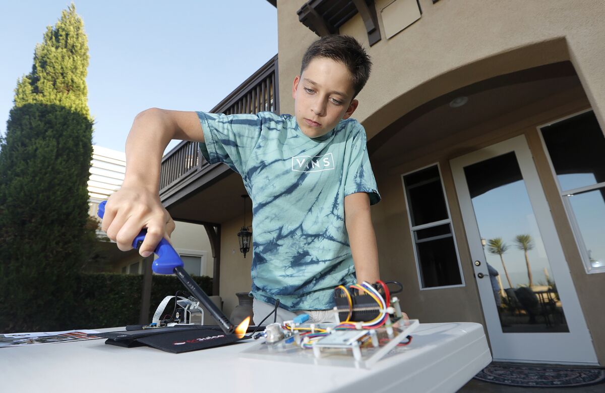 Ryan Honary, 12, prepares a demonstration of his early wildfire warning system 