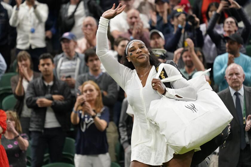 Serena Williams waves as she leaves the court after losing to France's Harmony Tan at Wimbledon on June 28.