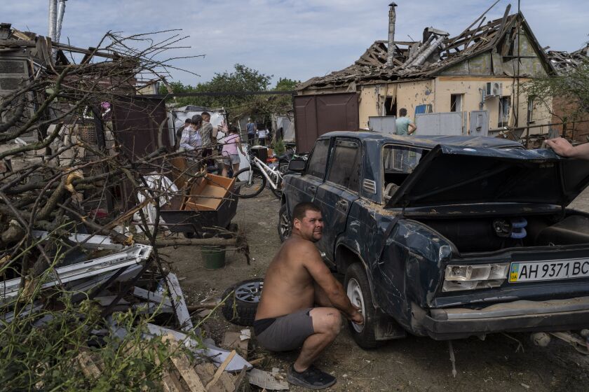 Residents recover belongings from their damaged houses after a missile strike in Druzhkivka, eastern Ukraine, Sunday, June 5, 2022. (AP Photo/Bernat Armangue)