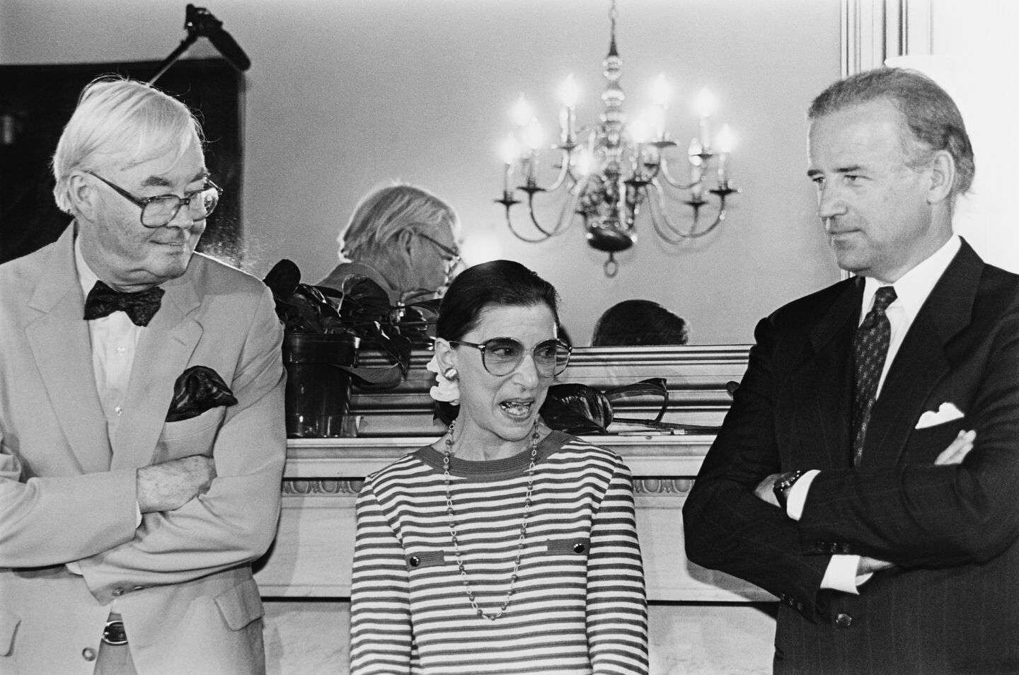 Black and white photo of Ruth Bader Ginsburg standing between Senators Daniel Patrick Moynihan and Joe Biden