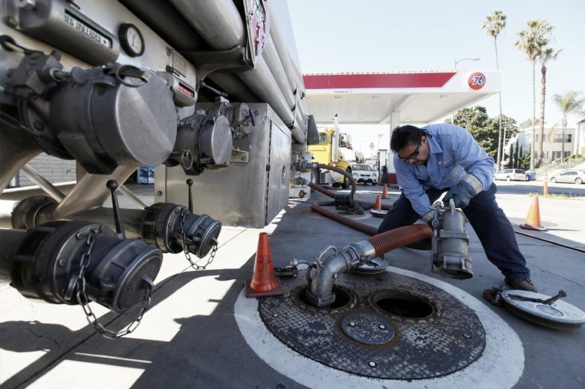 Freddy Lozoga fills an underground tank at a service station in Los Angeles. The one-month increase in Southern California gas prices is a record.
