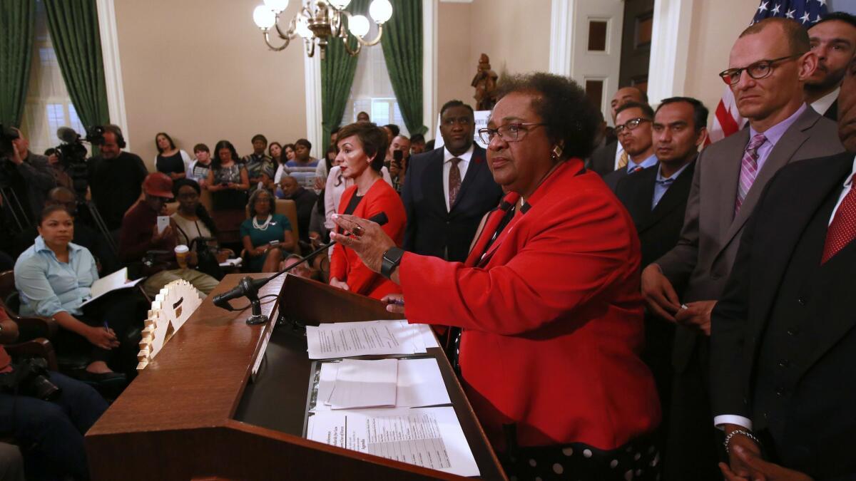 Assemblywoman Shirley Weber (D-San Diego), center, listens to a question during a news conference announcing her bill on police prosecutions Tuesday in Sacramento.
