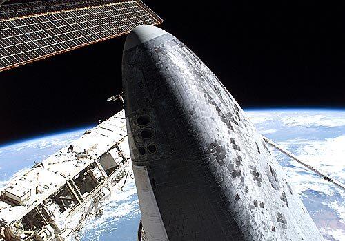 The blackness of space and Earth's horizon form the backdrop for this image featuring the nose of Discovery while docked to the International Space Station.