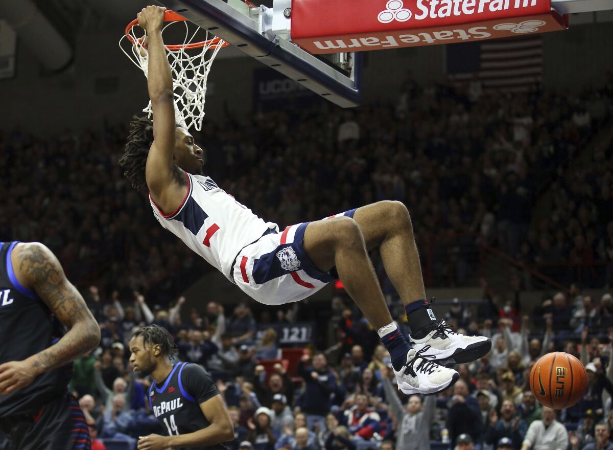 Connecticut's Isaiah Whaley (5) slam dunks the ball during the first half of an NCAA college basketball game against DePaul Saturday, March 5, 2022, in Storrs, Conn. (AP Photo/Stew Milne)