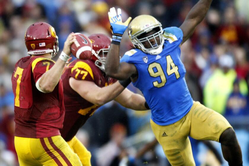 Bruins defensive end Owamagbe Odighizuwa (94) pressures USC quarterback Matt Barkley during their annual rivalry game two seasons ago.