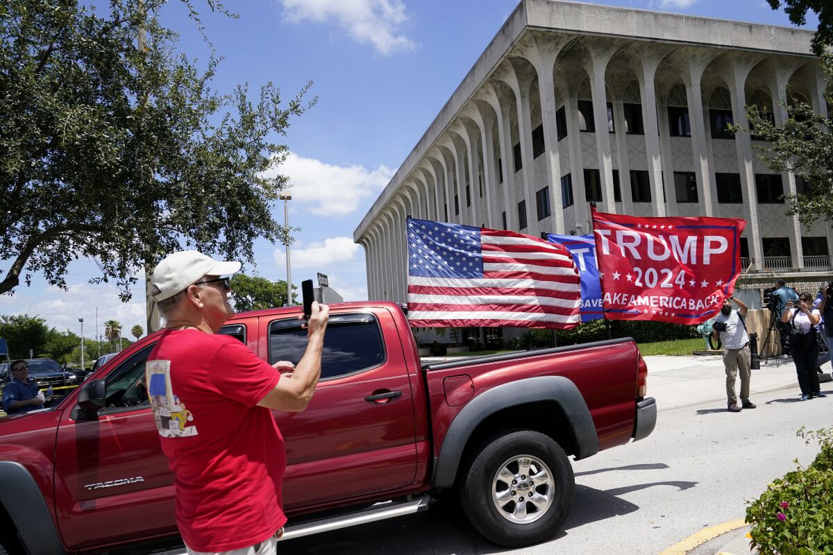 Un vehículo con banderas en apoyo a Donald Trump circula fuera de la Corte Federal Paul G. Rogers, el jueves 18 de agosto de 2022, en West Palm Beach, Florida. (AP Foto/Lynne Sladky)