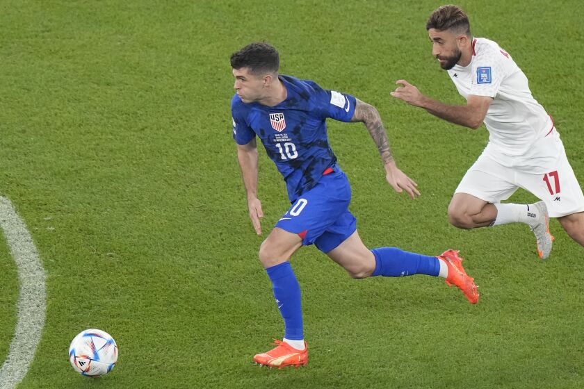 Christian Pulisic of the United States dribbles past Iran's Ali Gholizadeh during the World Cup group B.
