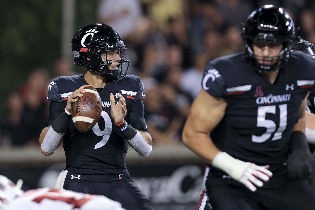 Cincinnati quarterback Desmond Ridder drops back to pass against Temple on Oct. 8, 2021.