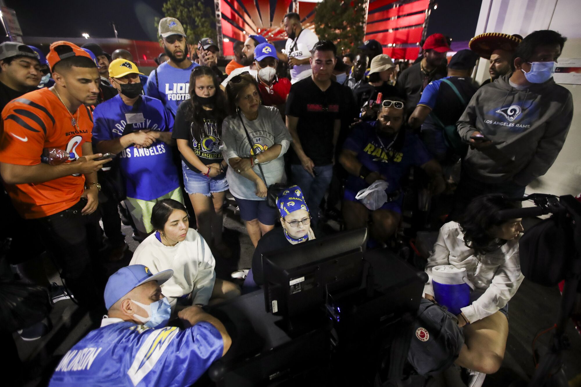 Fans watch the game on the streets outside of the stadium during the second half in Super Bowl LVI at SoFi Stadium.