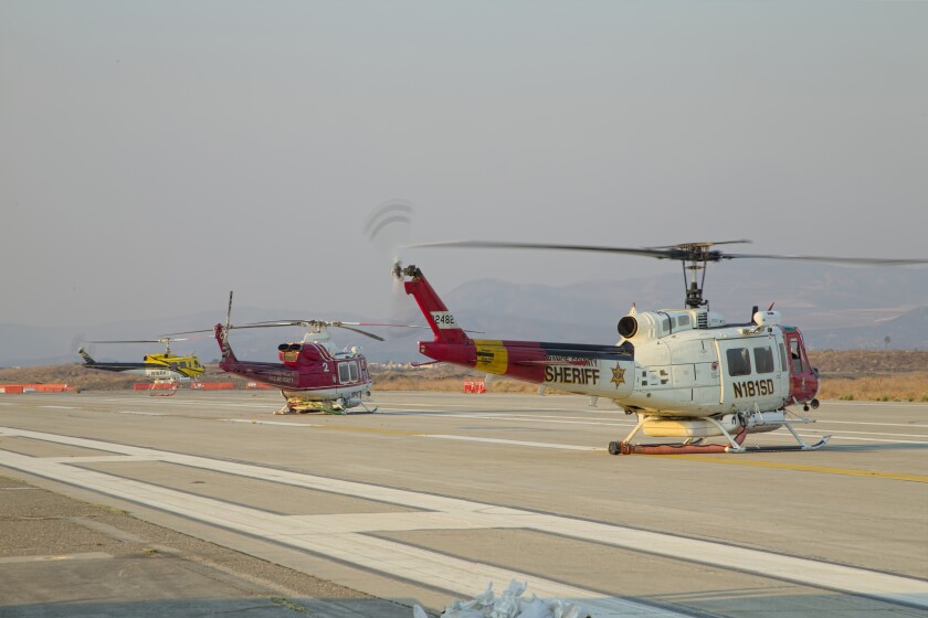 OCSD Air Support’s Bell UH-1V Huey “Duke 7,” right, after landing from a day of water drops.