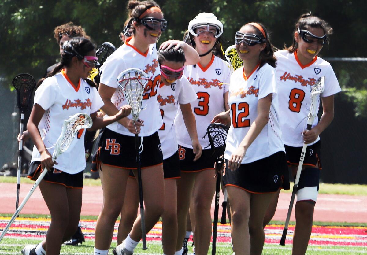 The Huntington Beach girls' lacrosse team is all smiles as Megan Romero (2) is congratulated after a goal.
