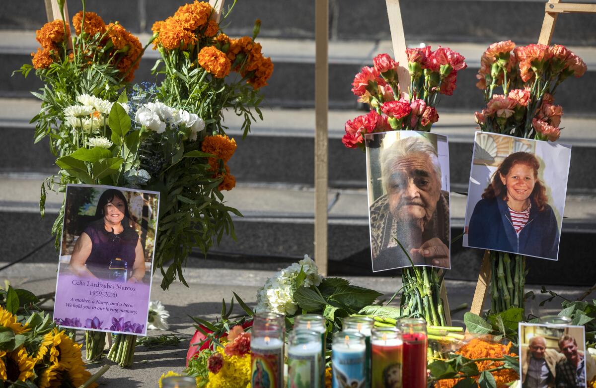 Fotos de pessoas que morreram na pandemia, incluindo Celia Marcos, à esquerda, fazem parte de um memorial no centro de Los Angeles 