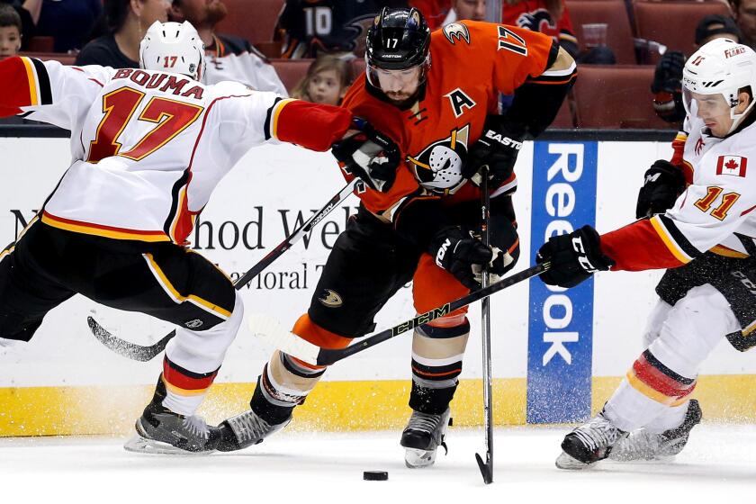 Ducks center Ryan Kesler splits the defense of Calcary's Mikael Backlund (11) and Lance Bouma during their game Sunday night in Anaheim.