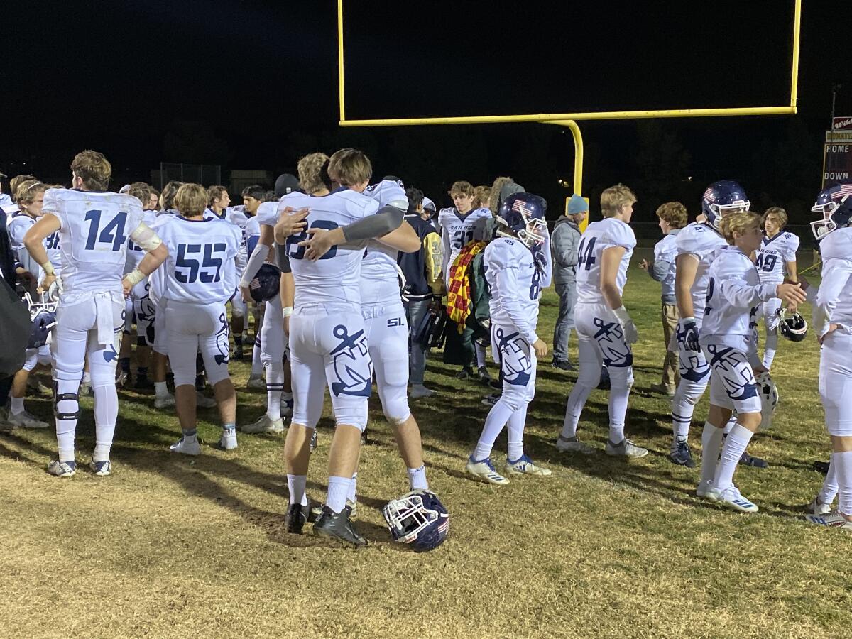 Newport Harbor players embrace after suffering a 58-17 loss to Highland in the semifinals of the CIF Southern Section Division 9 playoffs on Friday in Palmdale.