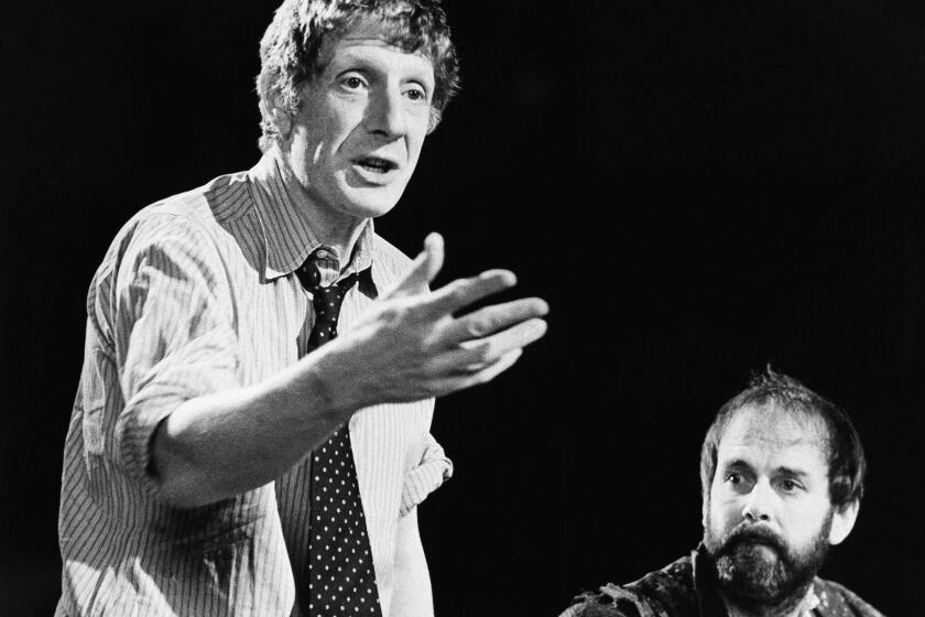 FILE - In this Dec. 12, 1980 file photo, Jonathan Miller, left, directs Shakespeare's "Taming Of The Shrew" with actor John Cleese, right. The family of theater director and presenter Jonathan Miller says the star of the “Beyond the Fringe’’ comedy revue has died. He was 85 and had suffered from Alzheimer’s disease before his death Wednesday Nov. 27, 2019. (AP Photo, File)