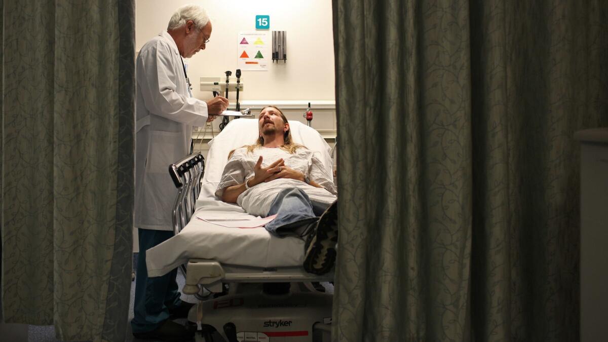 An emergency room doctor examines a patient at Providence St. Joseph Medical Center in Burbank, Calif. on February 23, 2012.