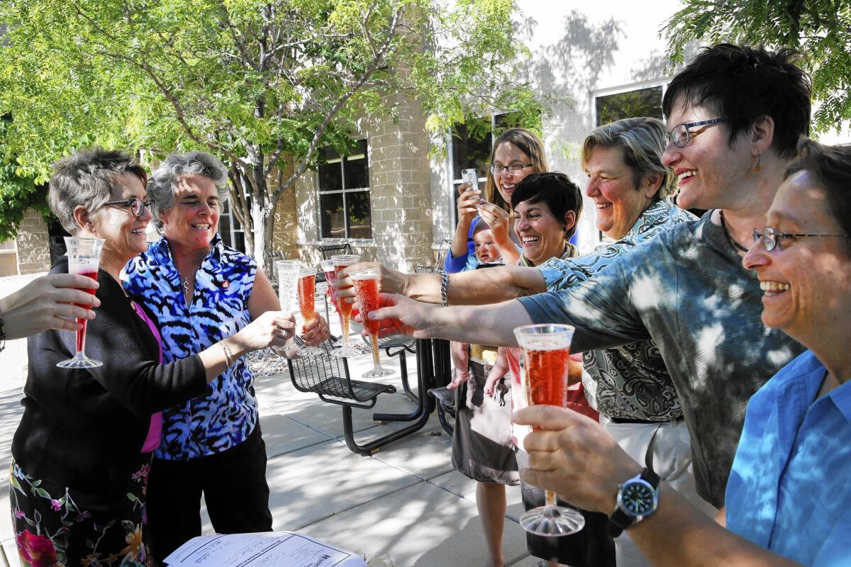 Angie Holley, left, and Bylo Farmer share a toast with friends celebrating their new marriage license.