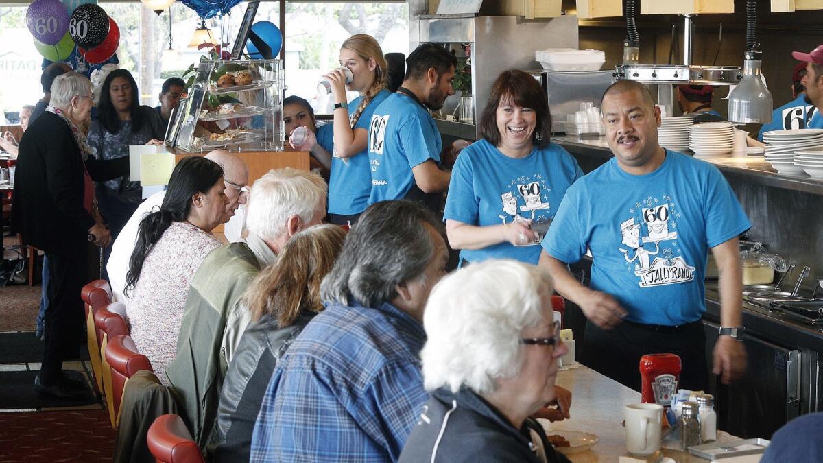 Crew members wear 60th anniversary T-shirts at a celebration at the Tallyrand restaurant in Burbank on Tuesday, April 30, 2019.