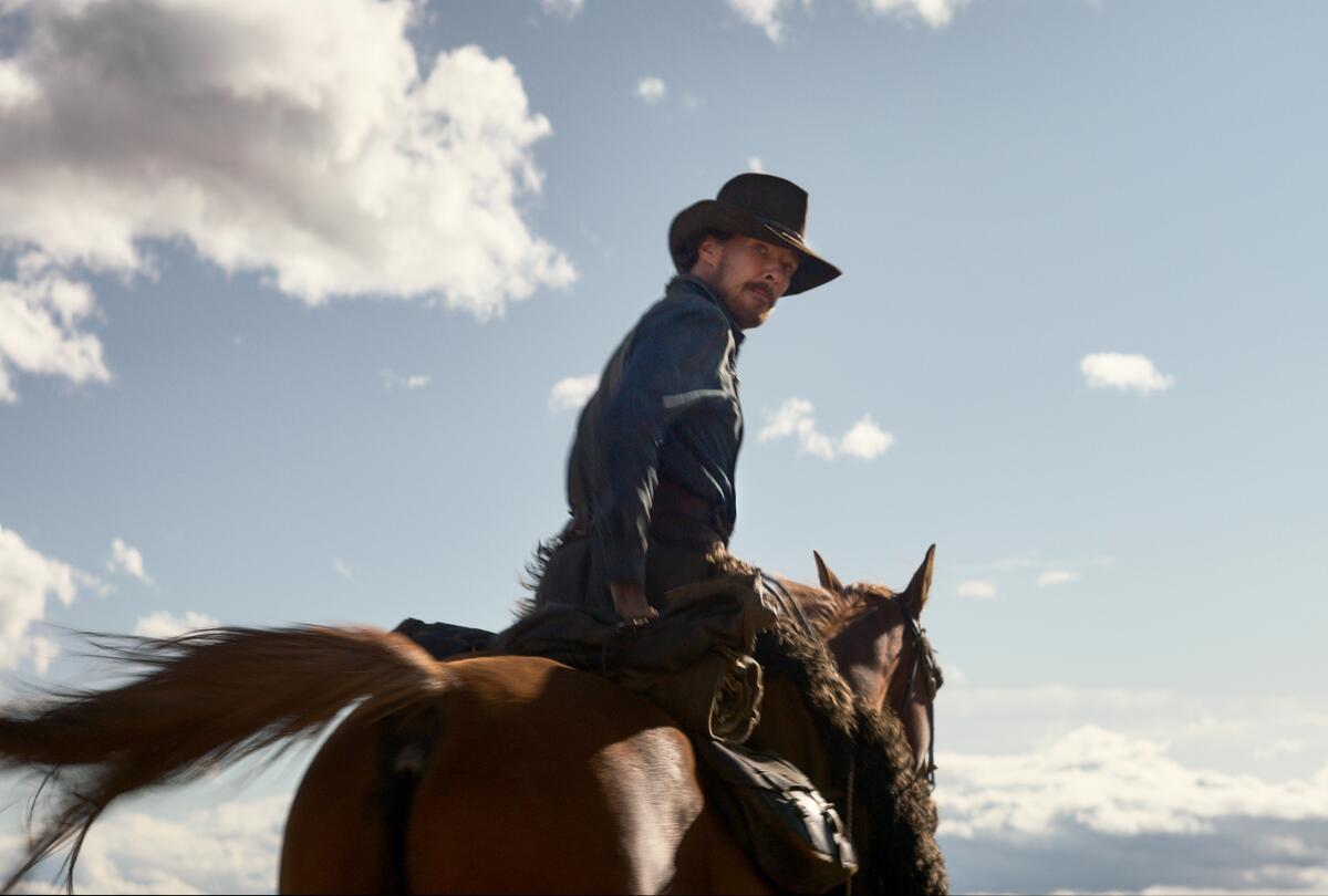 A man in cowboy hat riding a horse while looking back.