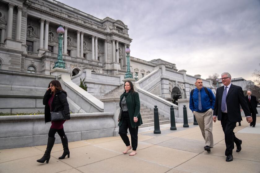 WASHINGTON, DC - FEBRUARY 07: (L to R) Trinity Alps Unified School District Director of Business Services Sheree Beans, Mountain Valley Unified School District Superintendent Anmarie Swanstrom, walking barefoot, Trinity Alps Unified School District Superintendent Jamie Green and Northern Humboldt Unified School District Superintendent Roger Macdonald walk past the Library of Congress as they head to the Hart Senate Office Building for a meeting at the office of Sen. Alex Padilla (D-CA) on Capitol Hill, Tuesday, Feb. 7, 2023 in Washington, DC. The delegation of Rural California school district superintendents are in Washington to present a proposal for the Secure Rural Schools Act of 2023 to members of congress in hopes of establishing permanent funding to rural schools. (Kent Nishimura / Los Angeles Times)