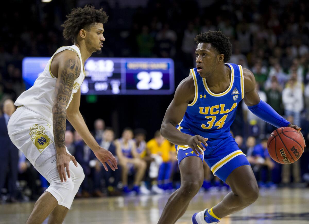 UCLA's David Singleton is pressured by Notre Dame's Prentiss Hubb during the first half Saturday.