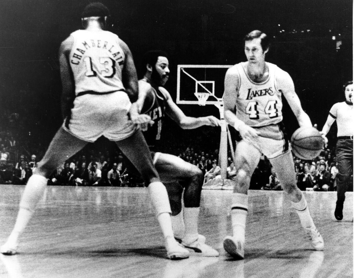 Lakers guard Jerry West drives to his left while Wilt Chamberlain sets a screen.
