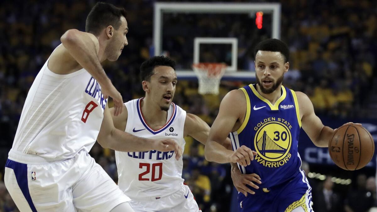 Golden State's Stephen Curry drives against Clippers' Danilo Gallinari, left, and Landry Shamet in the first half in Game 5.