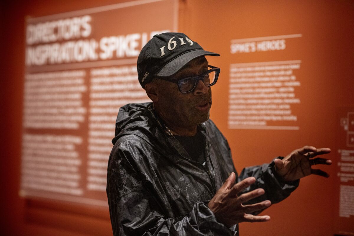 Director Spike Lee in a "1619" cap standing before the introduction to his exhibit at the Academy Museum of Motion Pictures.