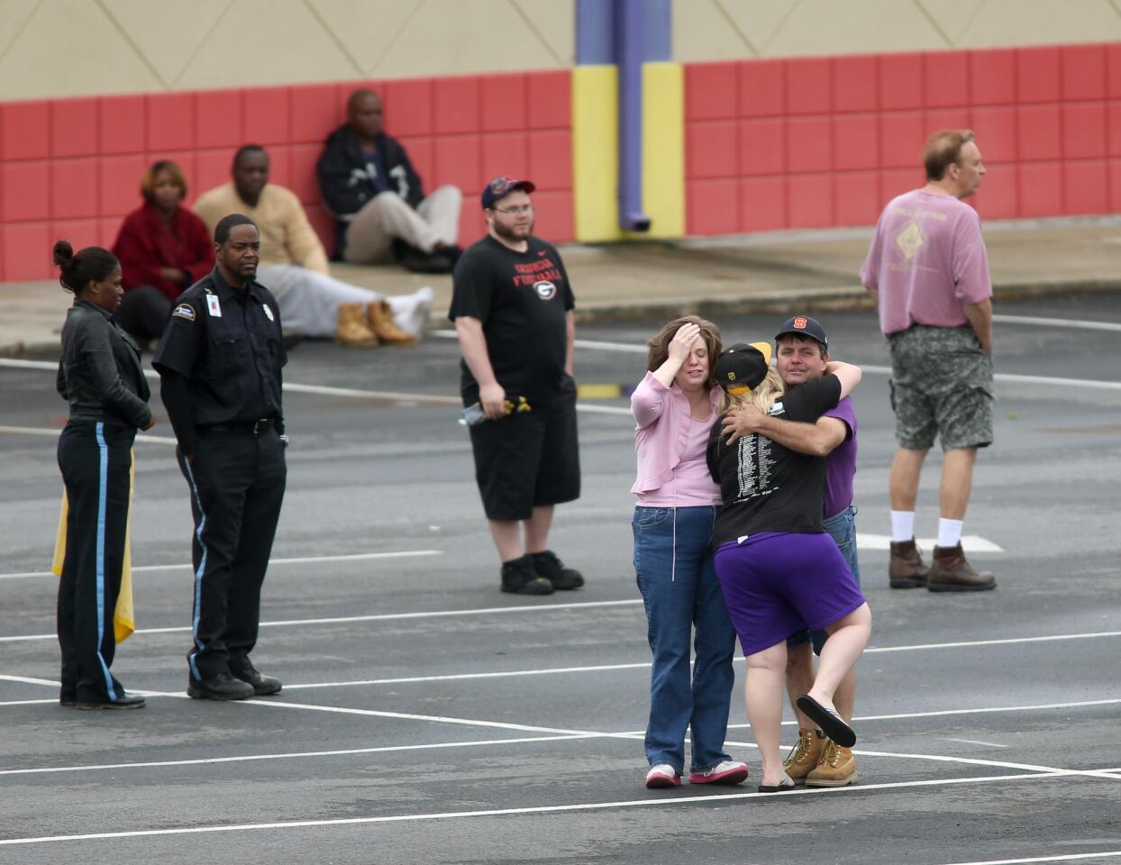A FedEx employee, facing, is consoled as other FedEx employees wait at a nearby business after an early morning shooting Tuesday.