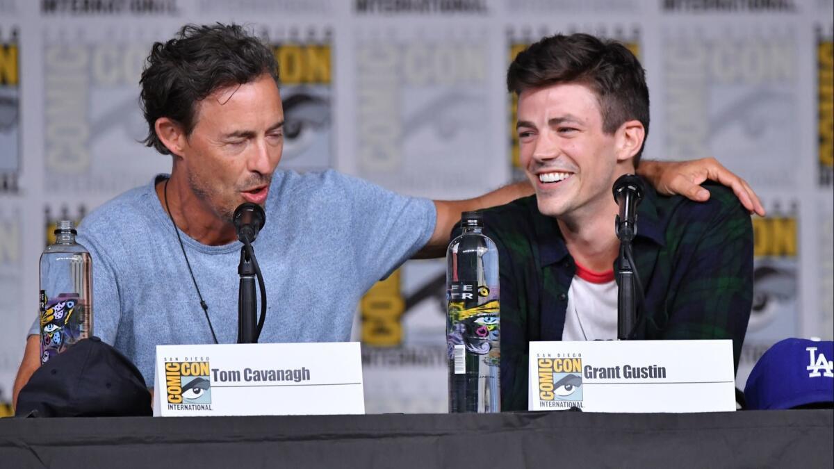 Tom Cavanagh and Grant Gustin speak onstage at the"The Flash" panel during Comic-Con International 2018.