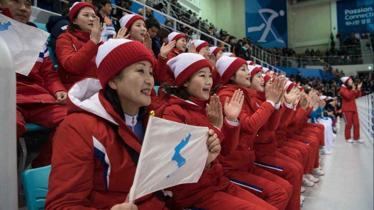 A member of the North Korean cheerleading team holds a flag depicting a united Korean peninsula during the women's hockey game Saturday.