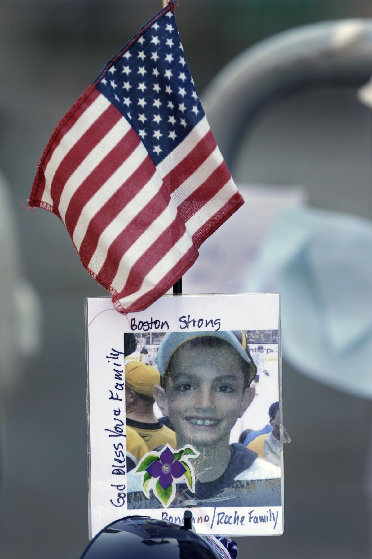 A photograph of bombing victim Martin Richard, 8, is attached to a barricade in Boston. The youngest victim in the bombing was buried Tuesday.
