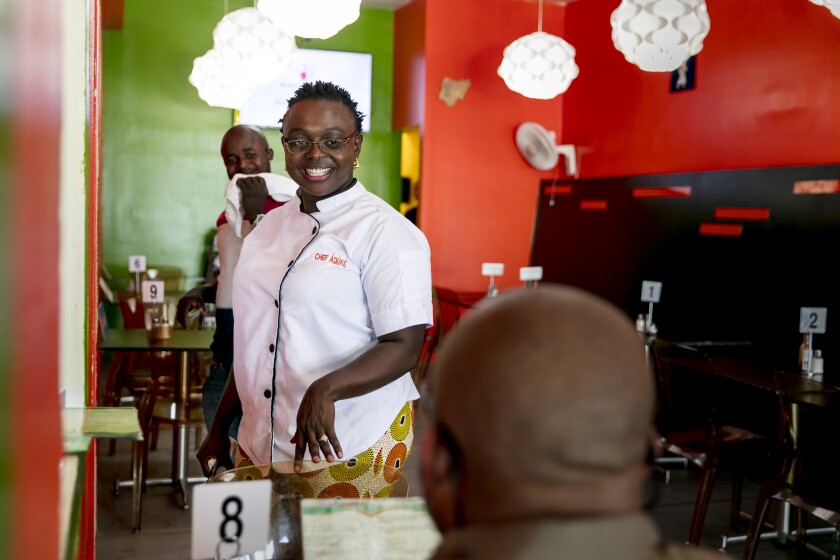 Aduke Oluwafunmilayo Oyetibo talks with a customer at her Mid-City restaurant, Aduke African Cuisine.