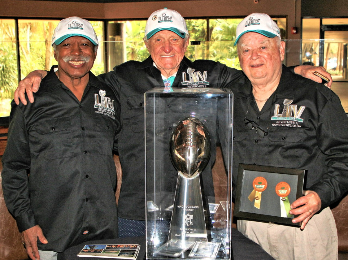 From left to right: Gregory Eaton, Tom Henschel and Don Crisman pose with a replica of the Vince Lombardi Trophy.