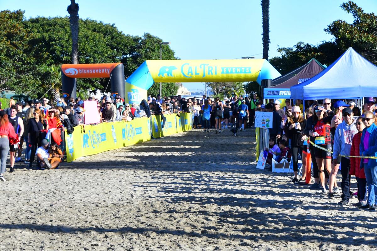 Spectators pack the start line of the 2023 Optimism Cal Tri Newport Dunes.