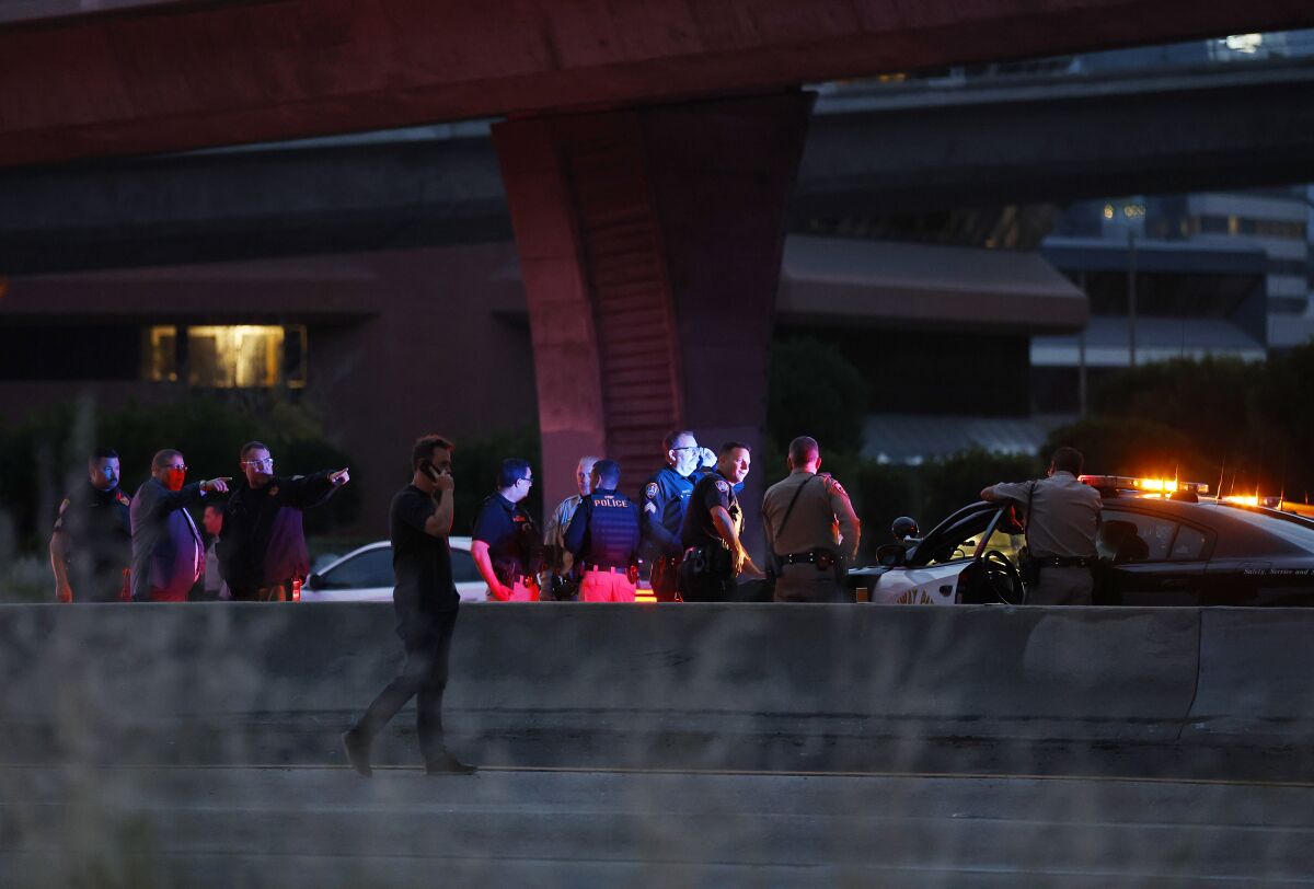 Police officers congregate on a closed freeway