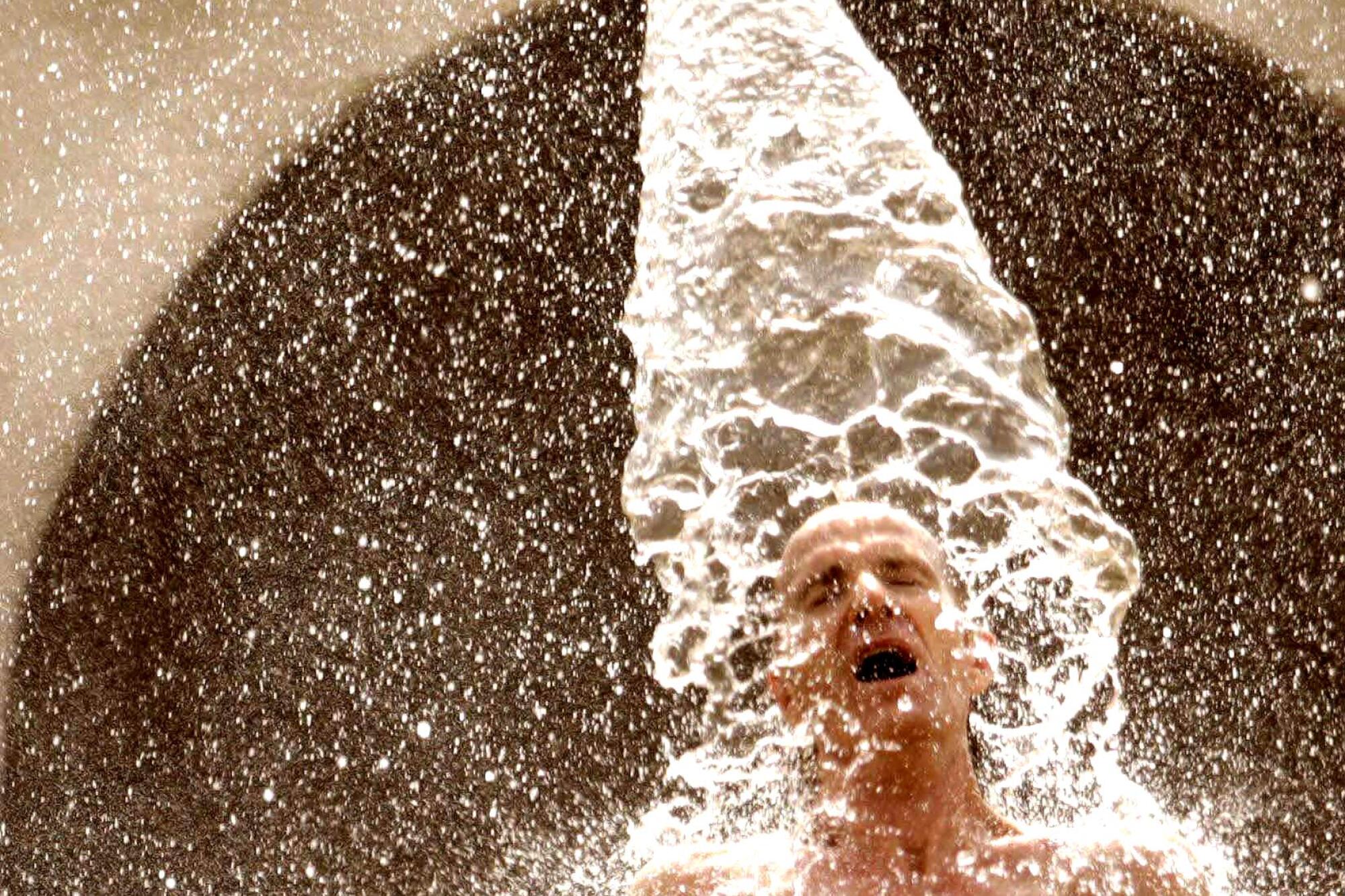 A man cools down in the splash pad area of the North Hollywood Pool