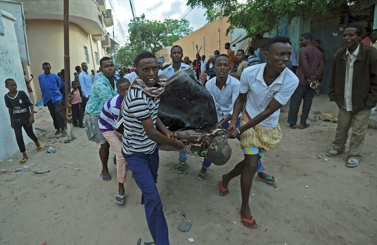 People carry a body from the Ambassador Hotel in Mogadishu after a terrorist attack June 2.