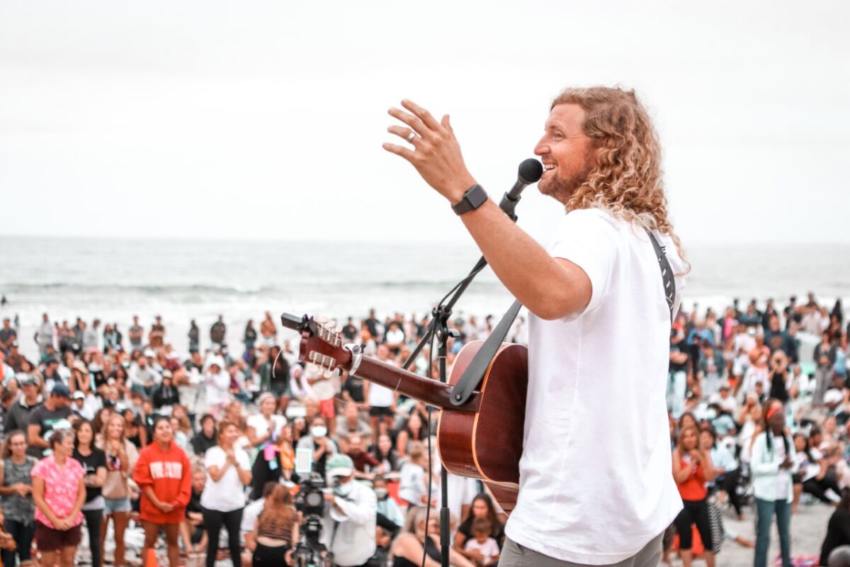Sean Feucht holds a worship service on Cardiff State Beach with many unmasked attendees crowded together.