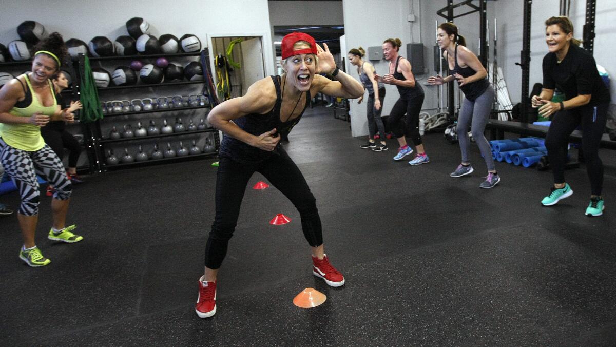 Fitness trainer Lacey Stone, center, leads her students through an exercise during a session of their two-week boot camp class at Lock Box L.A. on Pico Boulevard.