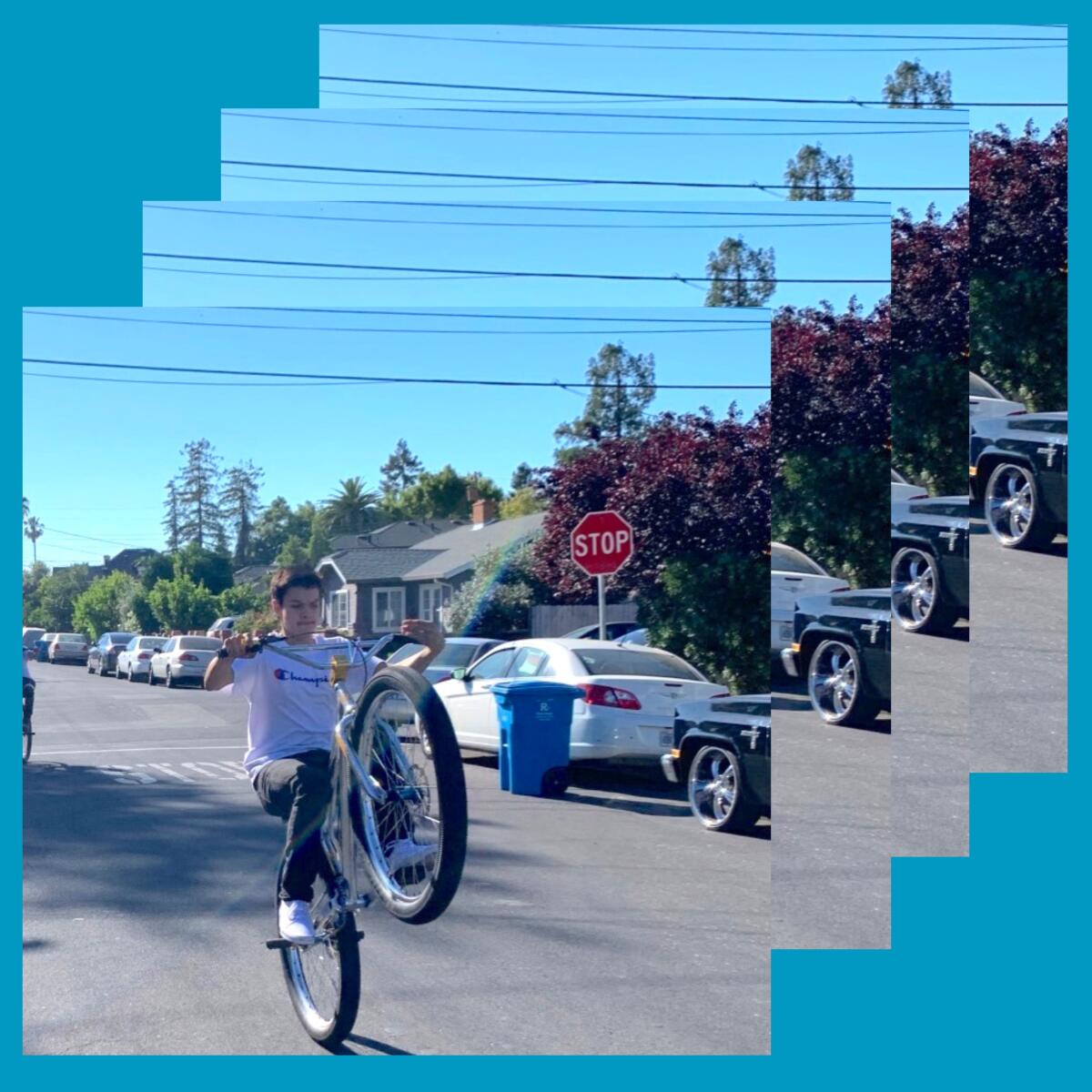 A boy popping a wheelie on his bike.