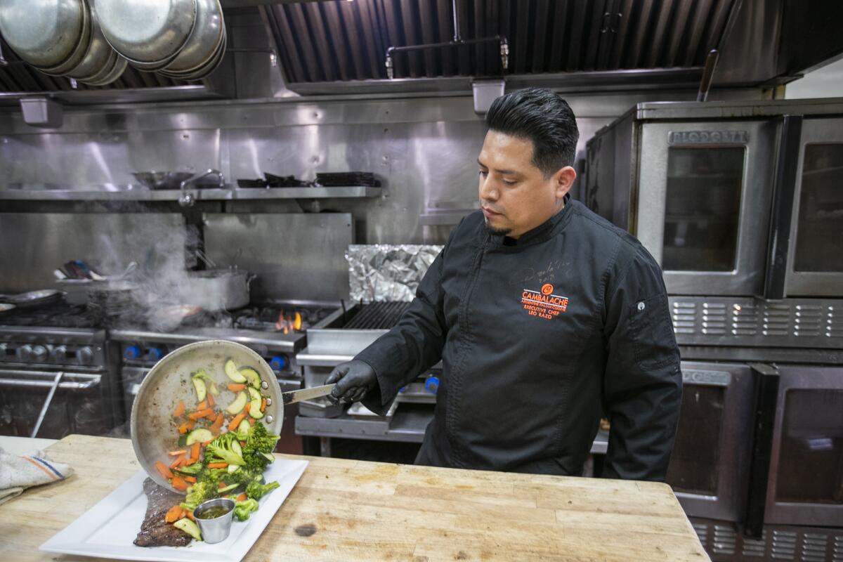 Freddy Mendez prepares a dish of skirt steak and vegetables on Tuesday.